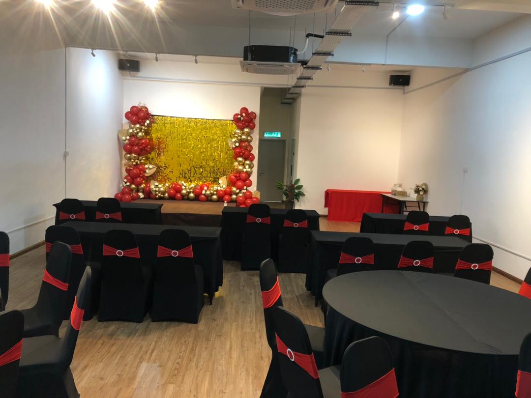 Celebration setup with stage and balloon backdrop